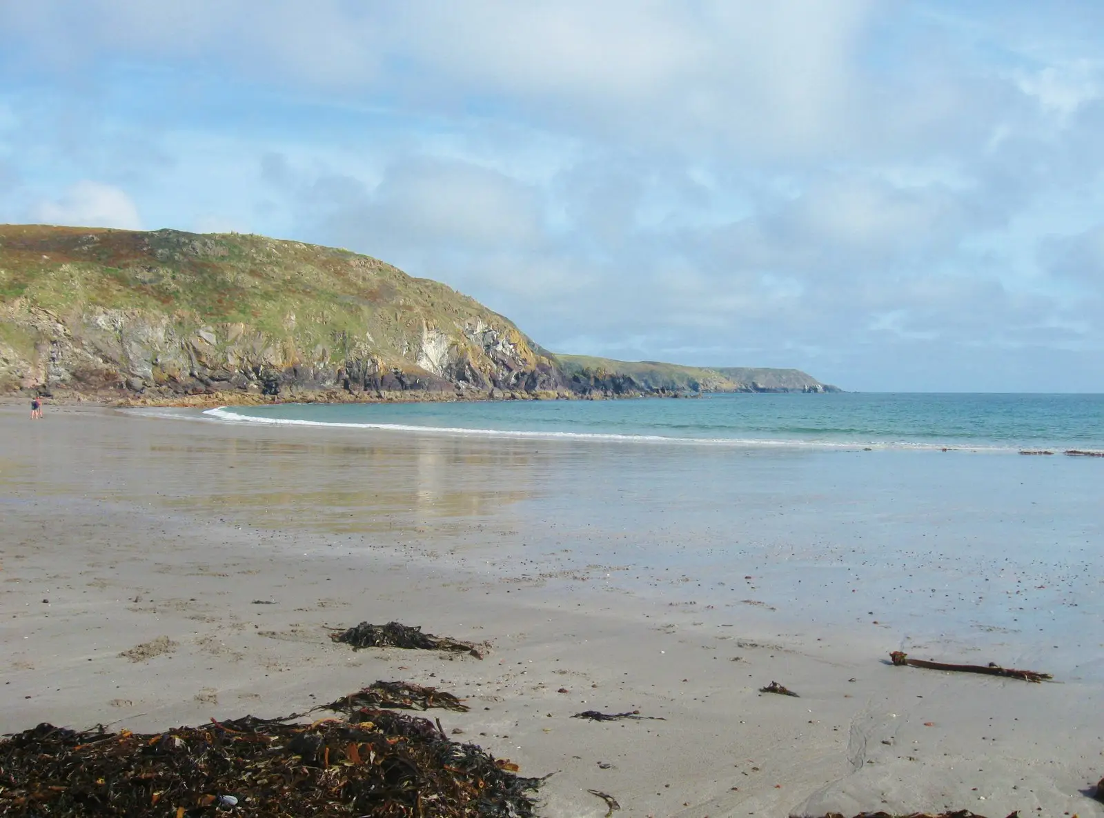 Kennack Sands from above — twin bays of sand divided by a low rocky outcrop, south-facing.