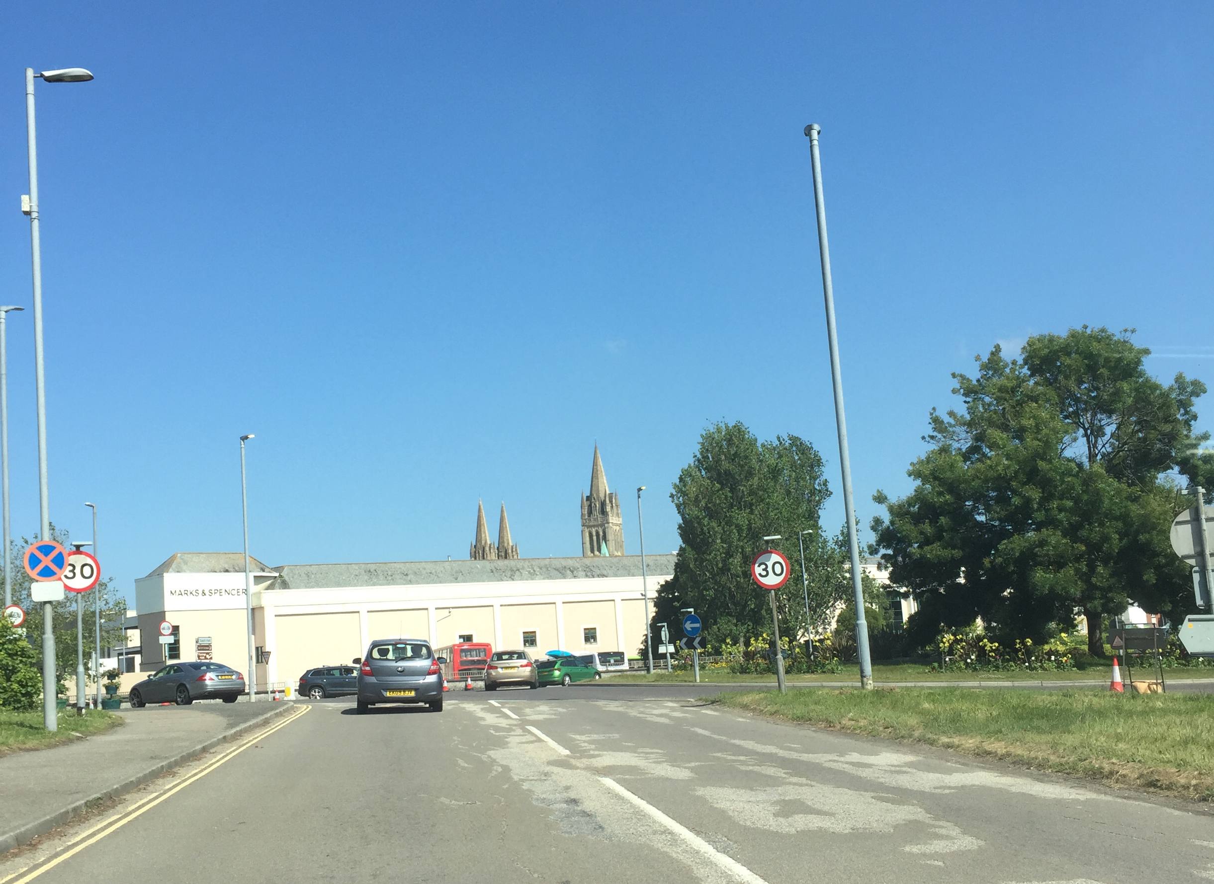 Truro Cathedral rising above the city rooftops on a grey day — Gothic Revival spires against overcast Cornish skies.