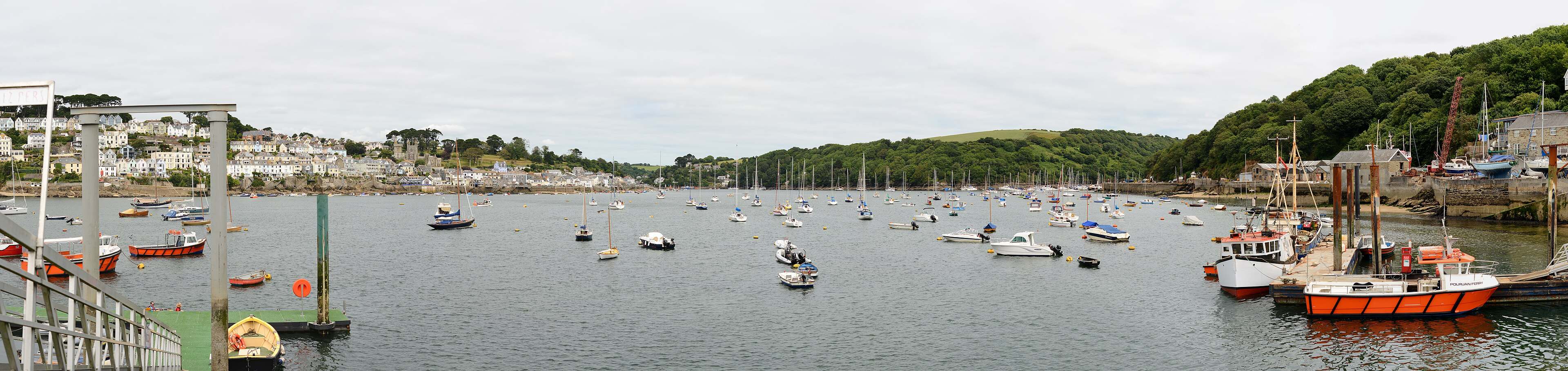 The Fowey estuary in soft afternoon light, terraced houses climbing the hillside.