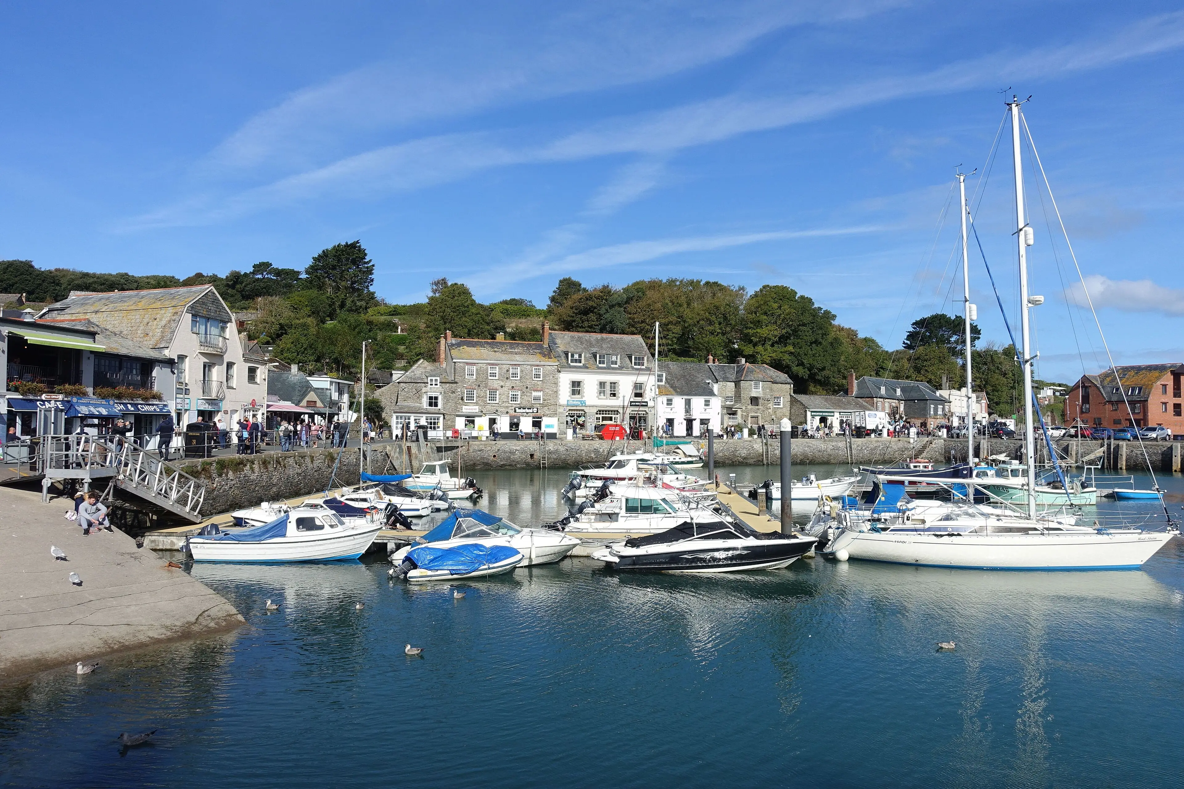 Padstow harbour — fishing boats moored in the estuary with the town rising behind.